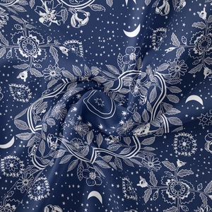 Detail of dark blue bohemian tapestry fabric with white moon and star patterns
