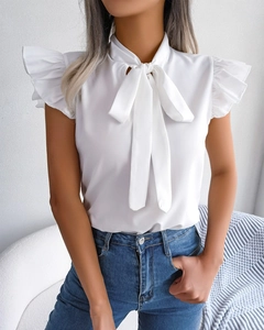 Close-up of elegant white blouse with layered ruffle sleeves and chic bow tie neckline