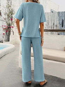 Rear view of light blue waffle knit set featuring short sleeve top and wide-leg trousers