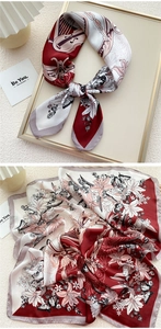 Close-up of elegant silk scarf with violin and lily floral pattern in burgundy and cream
