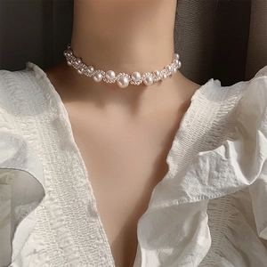 Luxurious white pearl choker necklace with interlaced pearls on model neck close-up