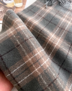 Gros plan détaillé du tissu écossais en cachemire synthétique avec texture tricotée et franges