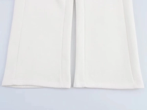 Detailed close-up showing the hem and premium fabric texture of white wide-leg trousers