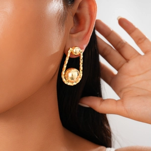 Primer plano de pendientes plisados en forma de U bañados en oro de 18K con esfera de metal