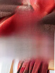 Detail of soft faux cashmere plaid scarf in red and brown with high-quality texture