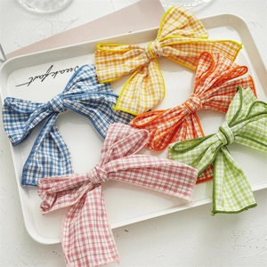 Detail of colorful gingham bow hair clips in blue, yellow, pink, and green fabrics