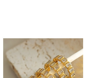 Close-up of gold-plated hoop earrings with rectangular baguette zirconias on stone