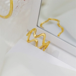Detailed view of 18K gold plated wavy gear textured ring with mirror finish texture