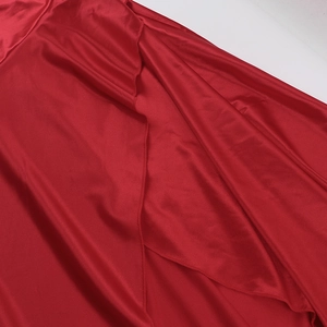 Detail of red satin fabric with elegant layered ruffles and textured sewing craftsmanship
