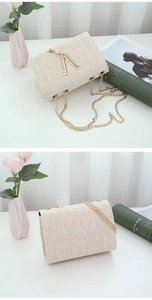 Detail of beige woven crossbody bag featuring a sparkling rhinestone V-shaped gold buckle