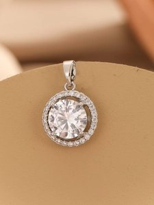 Macro shot of silver pendant with central round zircon and sparkling pave setting