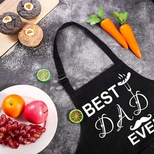 Black Best Dad Ever apron with white graphics on a stone surface backdrop