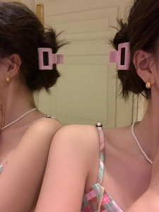 Pink matte rectangular claw clip shown on a half-up hairstyle in a real-life setting
