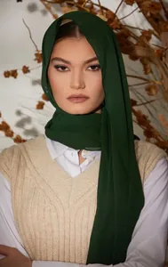 Detail of dark green 75D pearl chiffon headscarf texture worn with a beige knitted vest