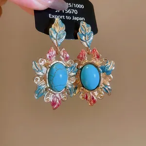 Vintage gold leaf drop earrings with blue main stone and enamel details on backing card