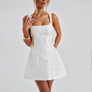 Détail du tissu jacquard blanc et de l'encolure carrée de cette élégante robe courte