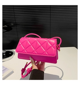 Détail du sac à bandoulière matelassé rouge rose en similicuir avec accents dorés
