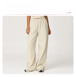 Detail of high-waist wide-leg sweatpants showing elastic drawstring and cream knit fabric