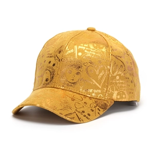Détail de la casquette dorée à finition métallique avec imprimés graffiti cœur et love