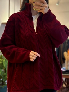 Detail of burgundy cable knit cardigan with zip-up half turtleneck and ribbed texture