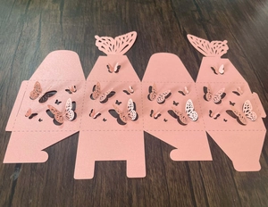 Flache Makroaufnahme der rosa lasergeschnittenen Geschenkbox mit Schmetterlingsdesign