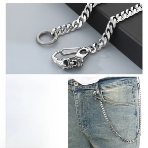 Detail of silver stainless steel Cuban link pants chain with skull carving on hook
