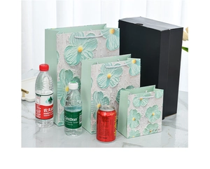 Detailed view of floral gift bags in three sizes with textured white flower patterns