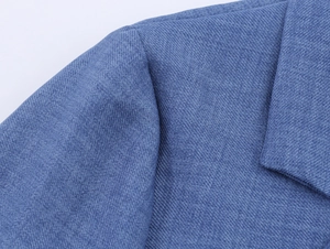 Close-up of blue lace blazer shoulder showing premium woven texture and stitching