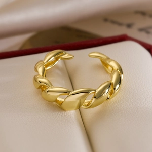 Minimalist twisted gold plated ring displayed in an elegant jewelry box with warm lighting