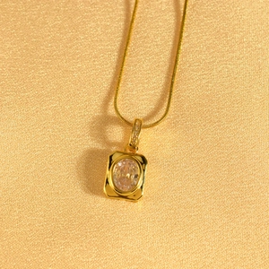 Macro shot of gold pendant featuring oval clear zircon and detailed micro-diamond accents