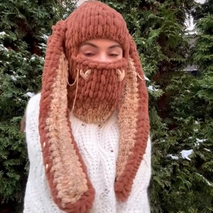 Detail of chunky knit balaclava with long rabbit ears and metal chain accents