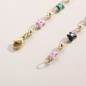 Detailed close-up of golden bead chain with colorful evil eye charms and lobster clasp