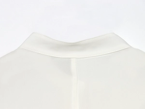 Close-up of white crew neck blouse showing delicate stitching and chiffon fabric texture