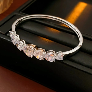 Détail du bracelet en argent avec zircons en cœur sur un coffret en cuir noir