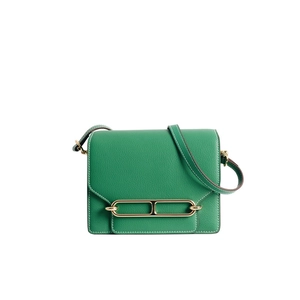 Dettaglio borsa in pelle verde con cuciture bianche a contrasto e fibbia in metallo oro