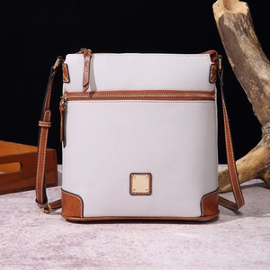 Close-up of grey litchi texture leather crossbody bag with brown trim and gold zippers