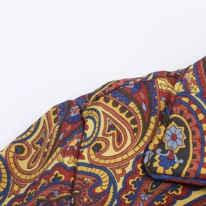 Close-up of paisley print fabric detail on the red and yellow shirt and pants set