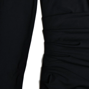 Detailed view of black long sleeve dress featuring premium pleated fabric texture