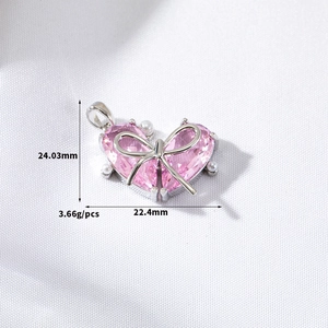 Macro shot of pink heart pendant with bow and pearls, showing 24.03mm height and 22.4mm width