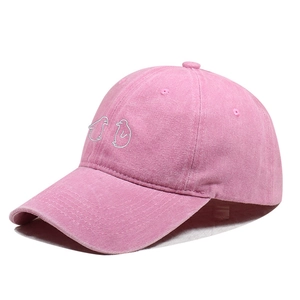 Detailopname van een gewassen roze honkbalpet met wit geborduurd pinguïnmotief