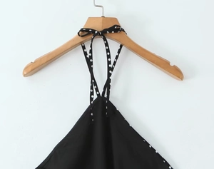 Close-up of black and white polka dot halter neck dress with elegant ribbon tie detail