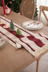 Detail of red and beige striped cotton linen table runner with tassels for Christmas