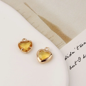 Détail de breloques cœur plaquées or avec zircons jaunes pour création de bijoux DIY