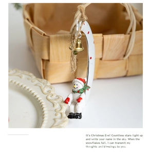 Detailed view of snowman Christmas ornament with red polka dot crescent and gold bell charm