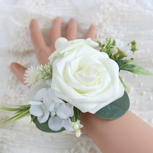 Elegant white rose wrist corsage with green leaves for brides and wedding events