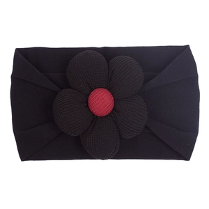 Detail showing high-elasticity nylon baby headband with a black flower and red accent
