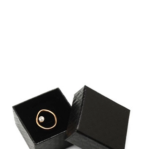 Close-up of golden irregular pearl ring presented in a black textured jewelry gift box