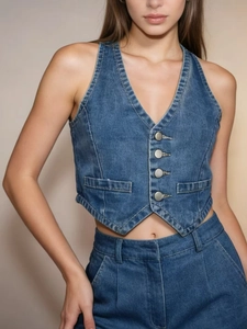 Detail of vintage denim vest with four buttons and high-quality stitching texture