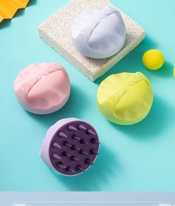 Detailed view of silicone scalp massager brushes in pink, yellow, white, and purple colors