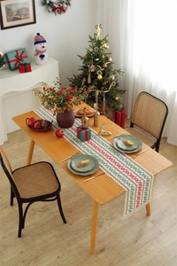 Close-up of woven cotton linen Christmas table runner with festive tassels and patterns